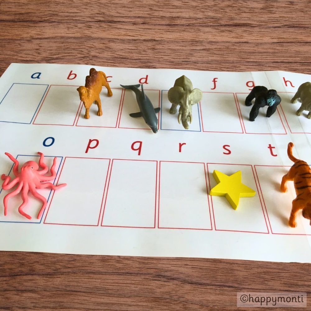 Montessori alphabet work mat with lowercase letters and phonetic objects like animals and a star. Hands-on language activity for teaching phonetic sounds and letter recognition. Designed by happymonti.