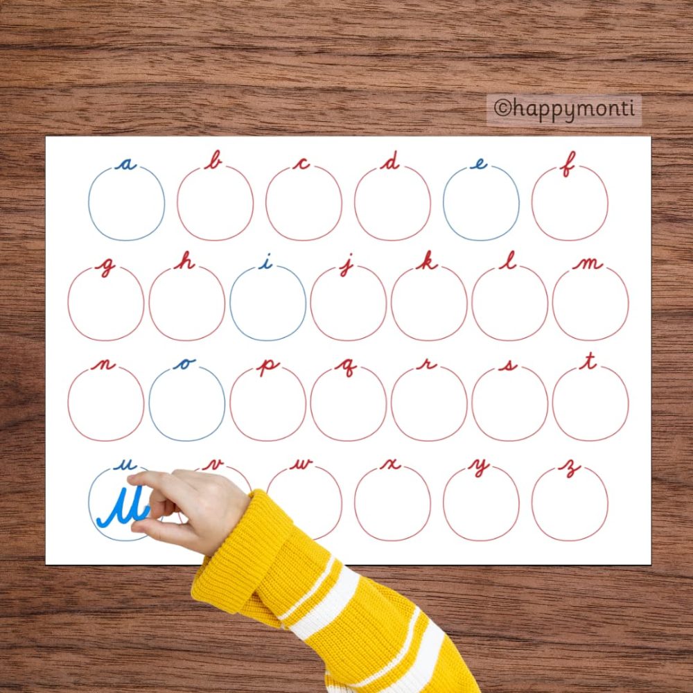 Montessori cursive alphabet mat with red and blue letters, interactive circles, and a child tracing the letter "u." Ideal for handwriting practice, phonics activities, and early literacy in Montessori education or homeschooling.